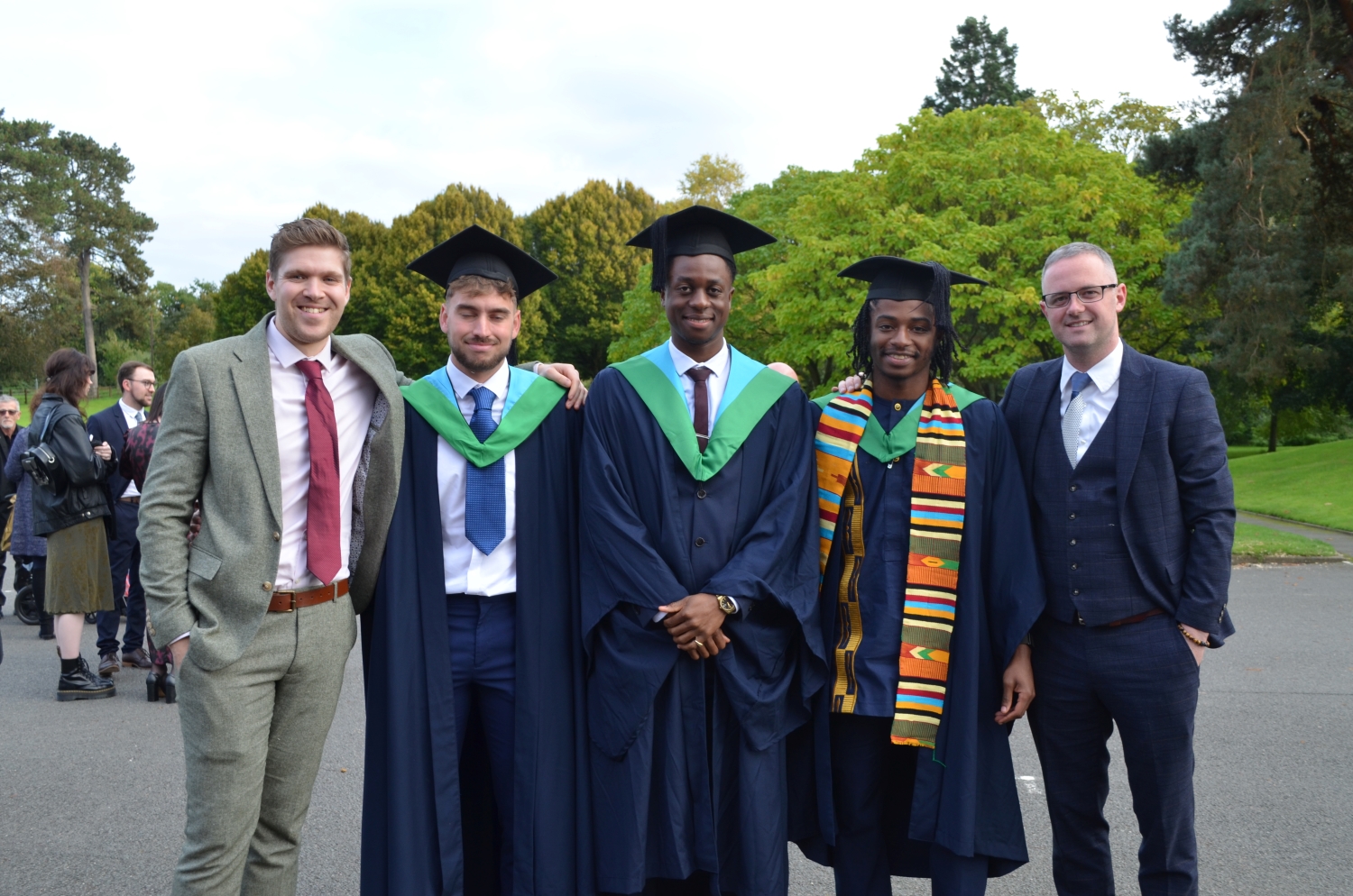 3 students with 2 teachers picture at graduation